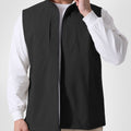 Man in black Men's Softshell Vest ¨C Lightweight Windproof Sleeveless, white long-sleeve tee & khaki pants, casual layered look.