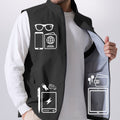 Pockets on black Men's Softshell Vest hold phone, sunglasses, ID, practical storage for daily or outdoor use.