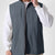 Man in light grey Men's Softshell Vest ¨C Lightweight Windproof Sleeveless, white long-sleeve tee & khaki pants, casual layered look.