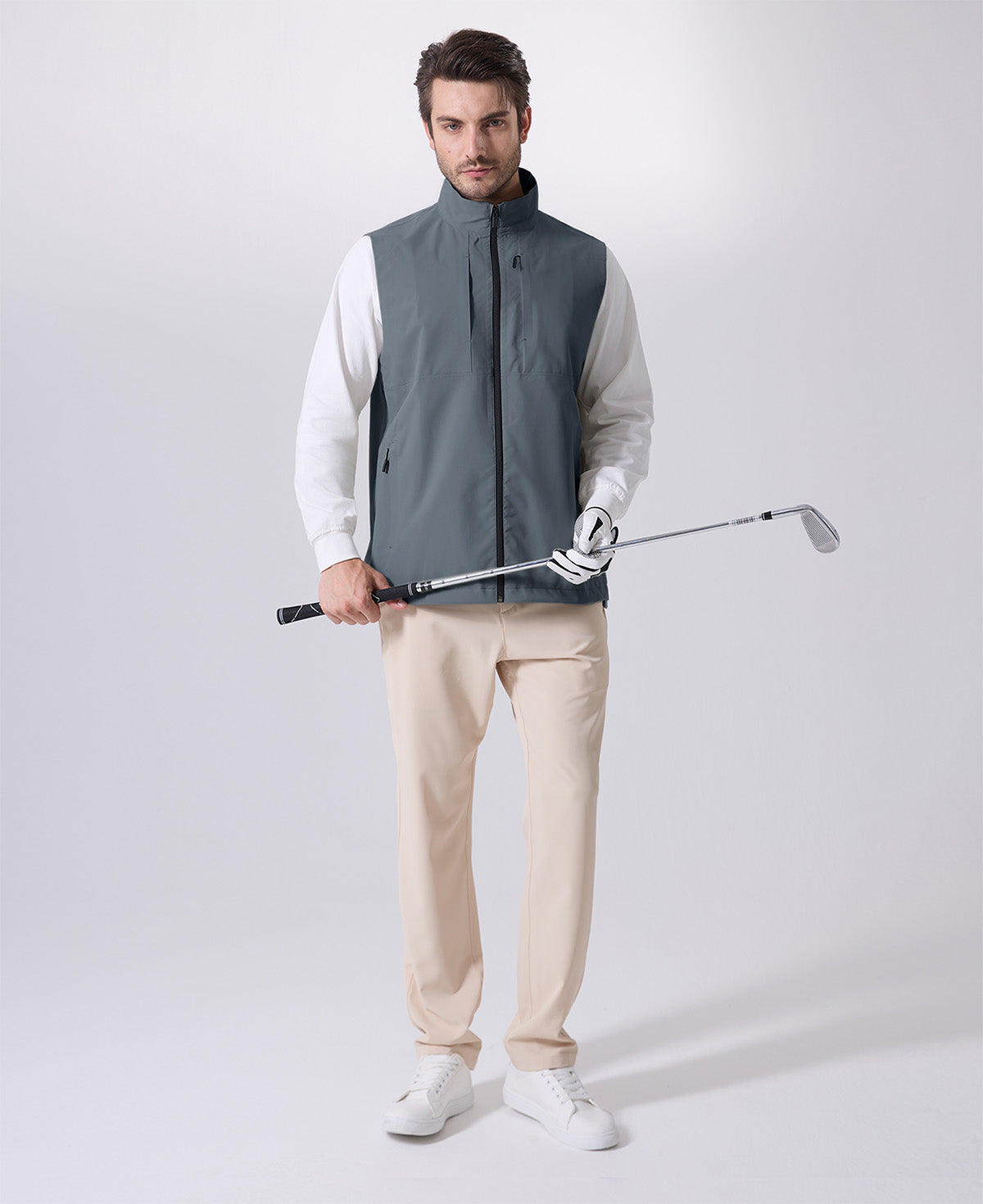 Model wearing light grey Men's Softshell Vest with golf club, ideal lightweight layer for outdoor leisure activities.