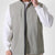 Man in sage green Men's Softshell Vest ¨C Lightweight Windproof Sleeveless, white long-sleeve tee & khaki pants, casual layered look.
