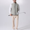 Model wearing sage green Men's Softshell Vest with golf club, ideal lightweight layer for outdoor leisure activities.