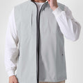 Man in white grey Men's Softshell Vest ¨C Lightweight Windproof Sleeveless, white long-sleeve tee & khaki pants, casual layered look.