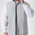 Man in white grey Men's Softshell Vest ¨C Lightweight Windproof Sleeveless, white long-sleeve tee & khaki pants, casual layered look.