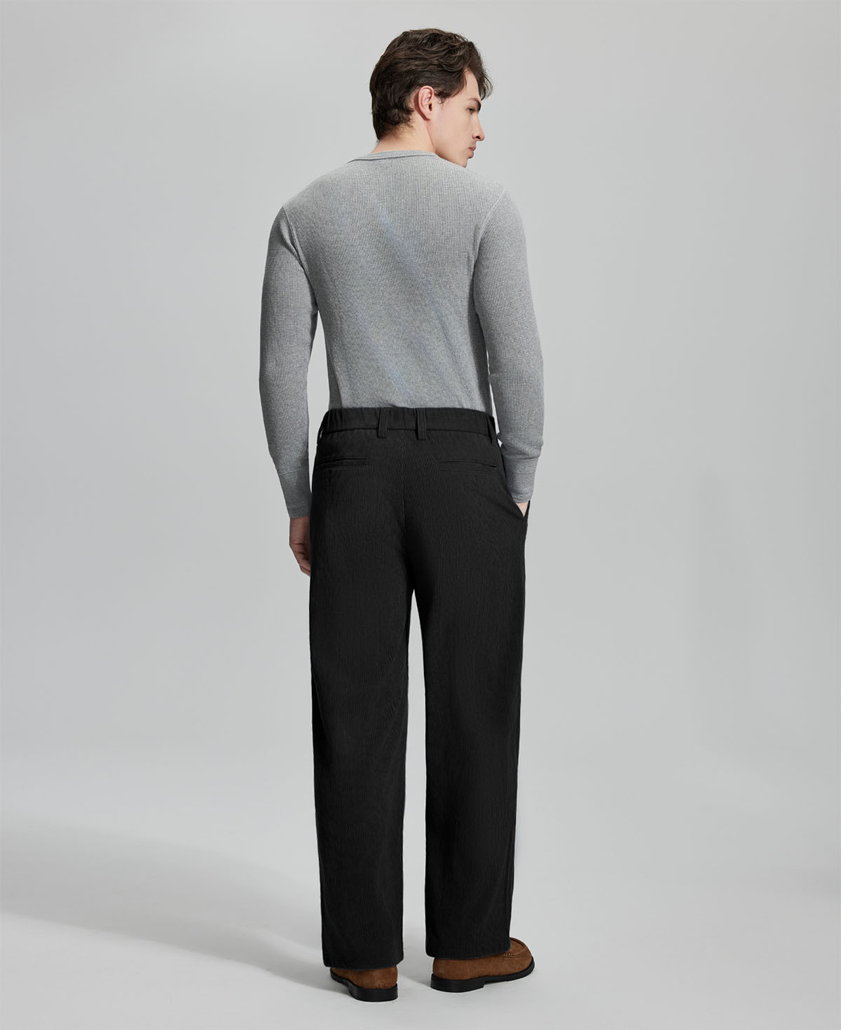 Back view of black wide-leg corduroy pants, showing overall silhouette and rear pocket design for comfort and style.