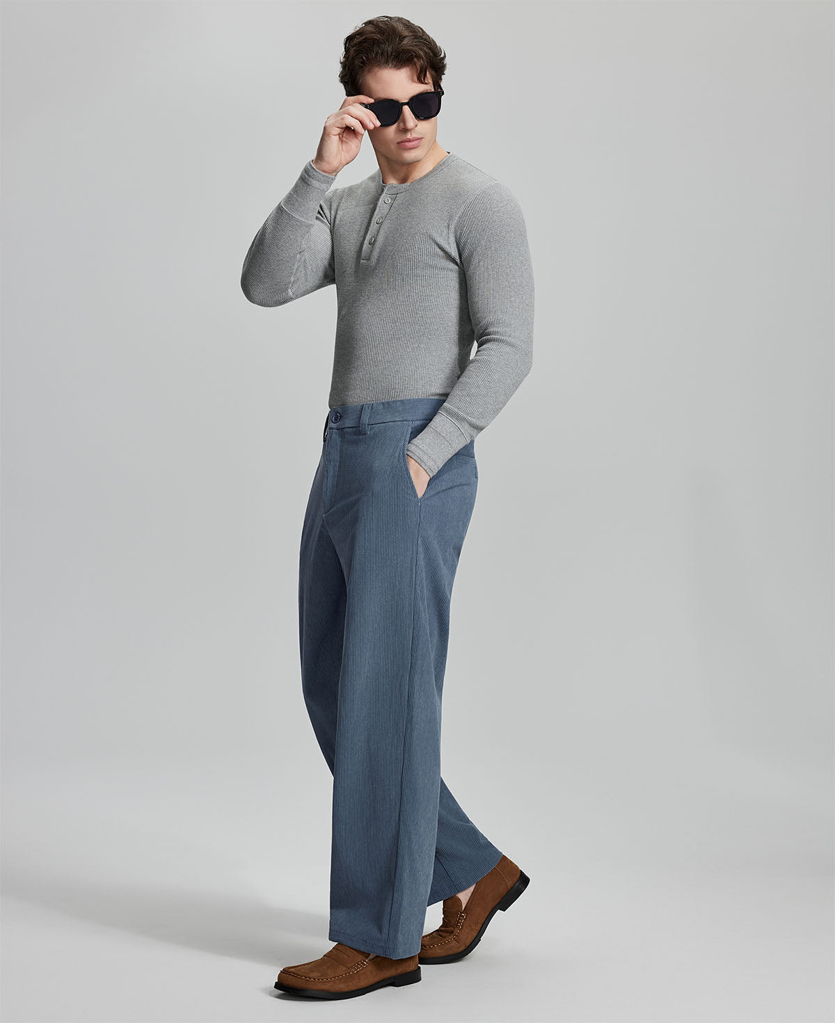 Side view of model wearing sunglasses with blue wide-leg corduroy pants, highlighting loose fit and style adaptability.