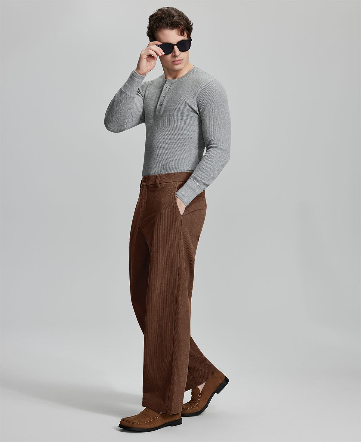 Side view of model wearing sunglasses with coffee wide-leg corduroy pants, highlighting loose fit and style adaptability.