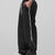 Man in black baggy wide leg sweatpants, side view, showing stripe detail and loose fit. White sneakers.