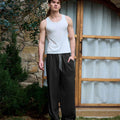 Full view of man wearing black baggy wide leg sweatpants, white sneakers, front stance, showing overall look.