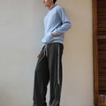 Man in black baggy wide leg sweatpants, showing both side and front views while standing.