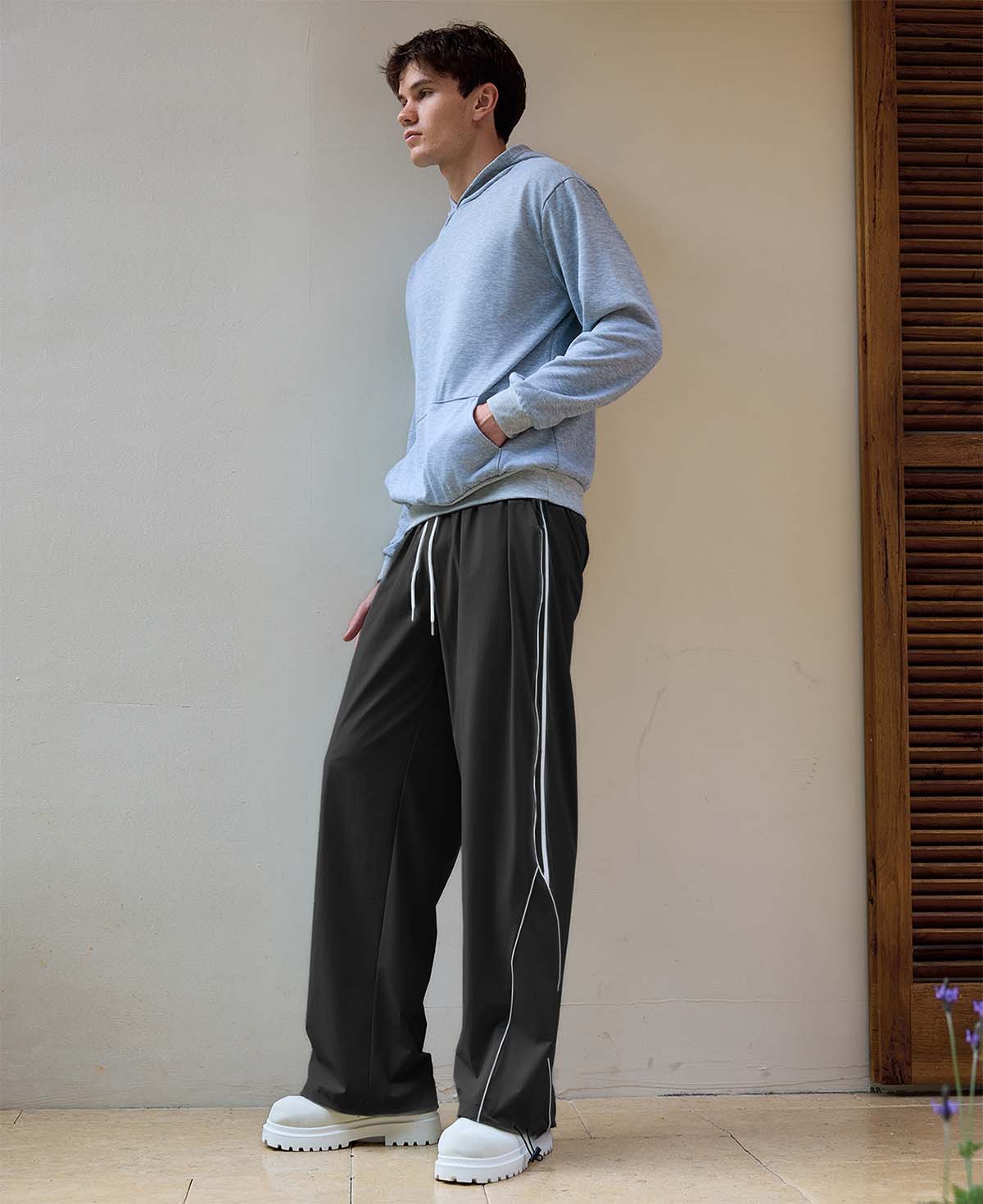 Man in black baggy wide leg sweatpants, showing both side and front views while standing.