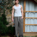 Full view of man wearing dark grey baggy wide leg sweatpants, white sneakers, front stance, showing overall look.