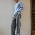 Man in dark grey baggy wide leg sweatpants, showing both side and front views while standing.