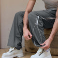 Adjustable drawstring at the hem of dark grey baggy wide leg sweatpants, showing stitching details and fabric texture.