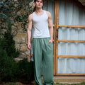 Full view of man wearing green baggy wide leg sweatpants, white sneakers, front stance, showing overall look.