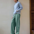 Man in green baggy wide leg sweatpants, showing both side and front views while standing.