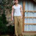 Full view of man wearing khaki baggy wide leg sweatpants, white sneakers, front stance, showing overall look.