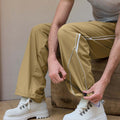Adjustable drawstring at the hem of khaki baggy wide leg sweatpants, showing stitching details and fabric texture.