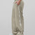 Man in light khaki baggy wide leg sweatpants, side view, showing stripe detail and loose fit. White sneakers.