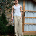 Man in light khaki baggy wide leg sweatpants, showing both side and front views while standing.