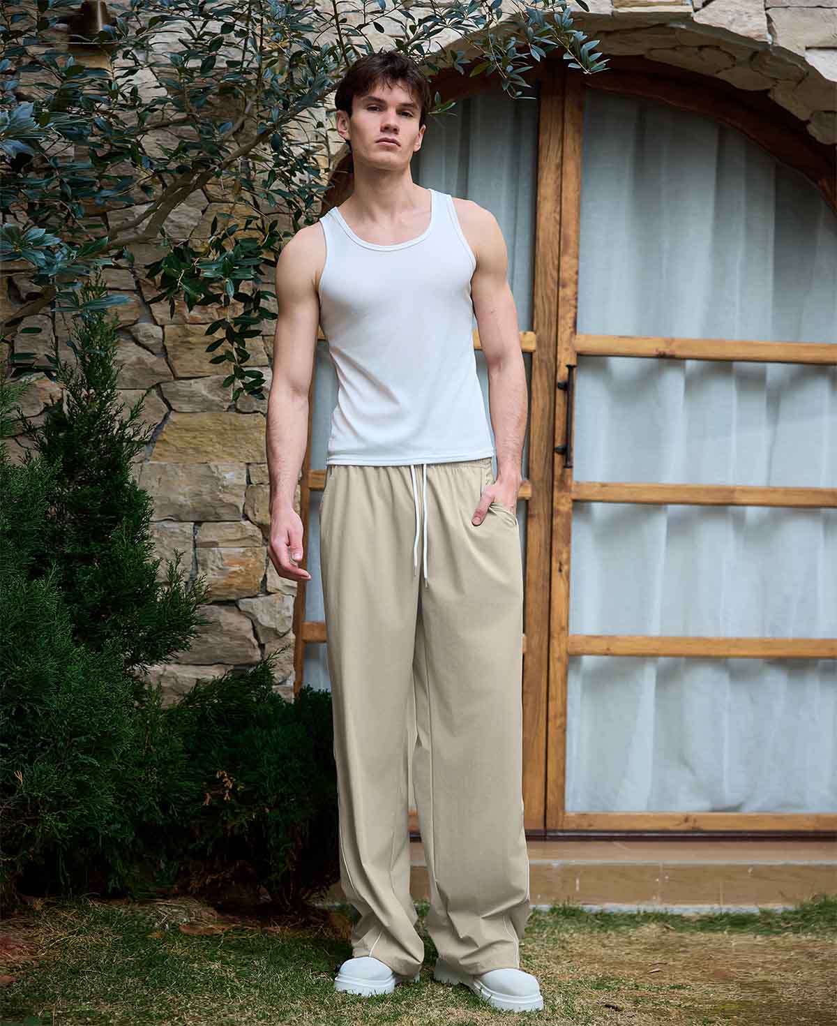 Man in light khaki baggy wide leg sweatpants, showing both side and front views while standing.