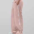 Man in pink baggy wide leg sweatpants, side view, showing stripe detail and loose fit. White sneakers.