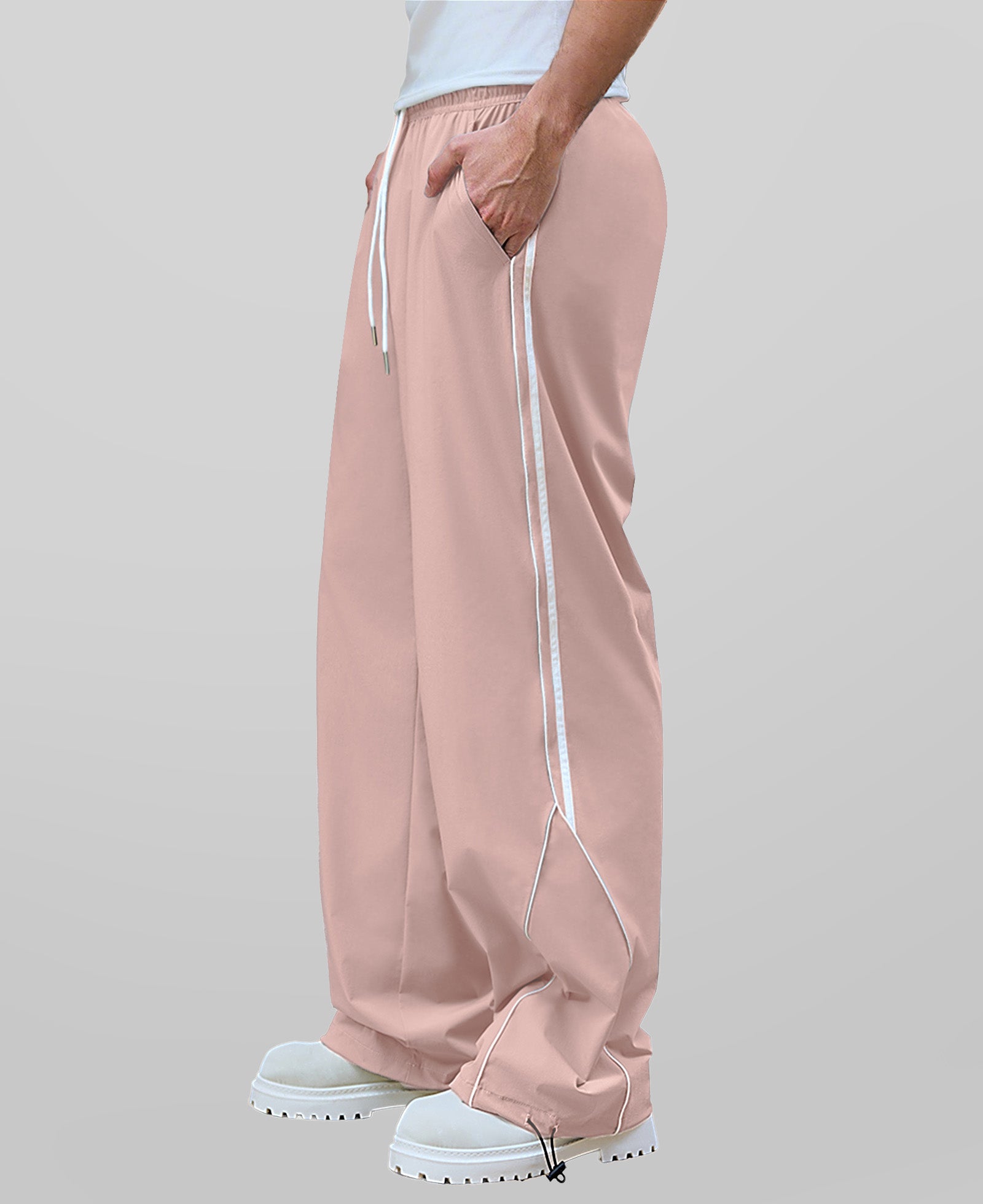 Man in pink baggy wide leg sweatpants, side view, showing stripe detail and loose fit. White sneakers.