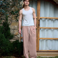 Full view of man wearing pink baggy wide leg sweatpants, white sneakers, front stance, showing overall look.