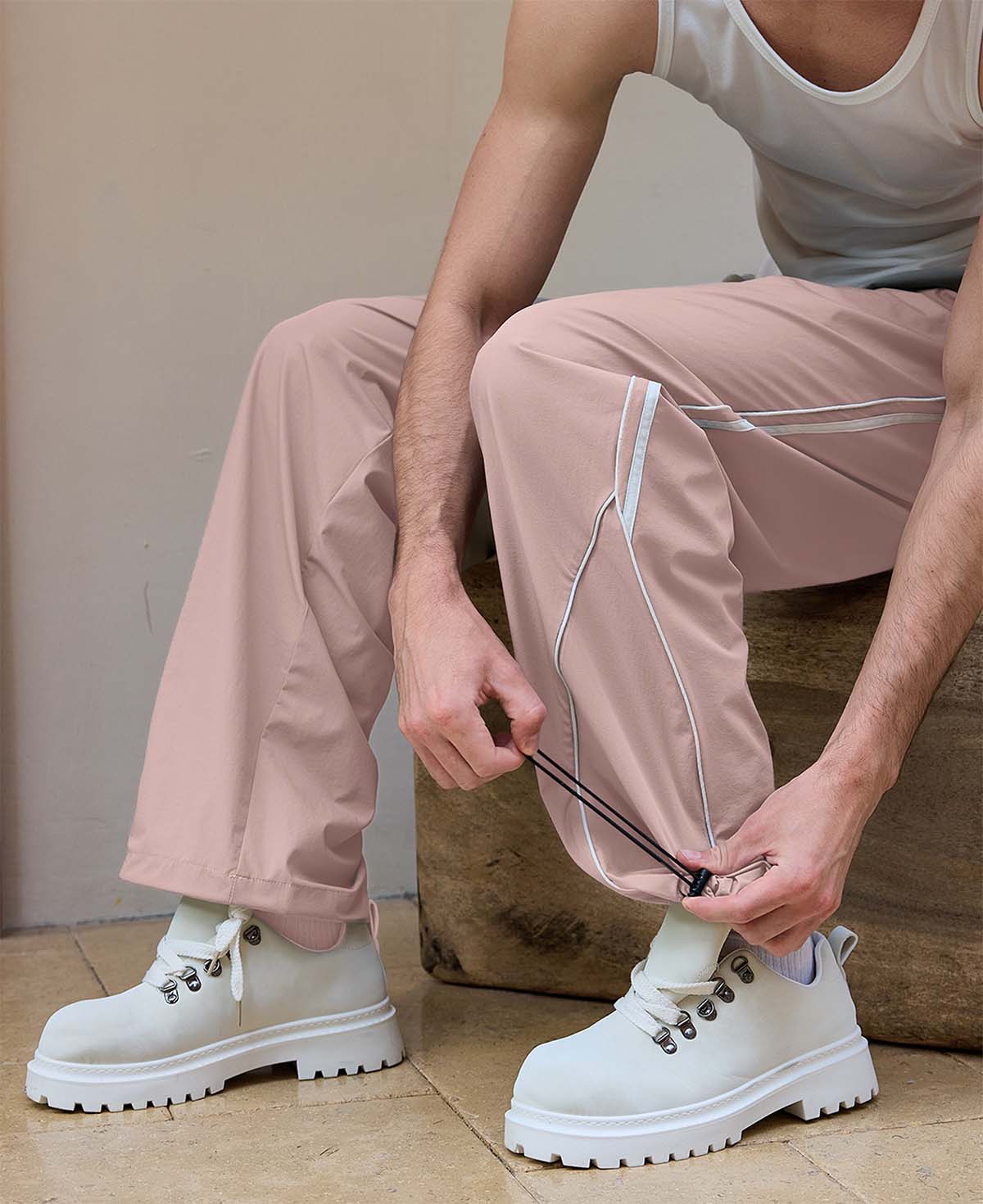 Adjustable drawstring at the hem of pink baggy wide leg sweatpants, showing stitching details and fabric texture.