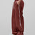 Man in red baggy wide leg sweatpants, side view, showing stripe detail and loose fit. White sneakers.