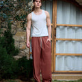 Full view of man wearing red baggy wide leg sweatpants, white sneakers, front stance, showing overall look.